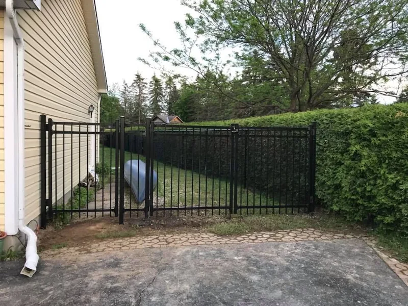 Black aluminum fence and gate closing off a driveway