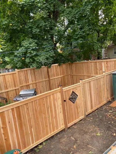 Full height wood privacy fence enclosing a back yard