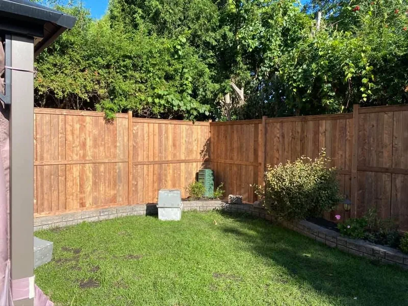 Wood fence enclosing a landscaped back yard
