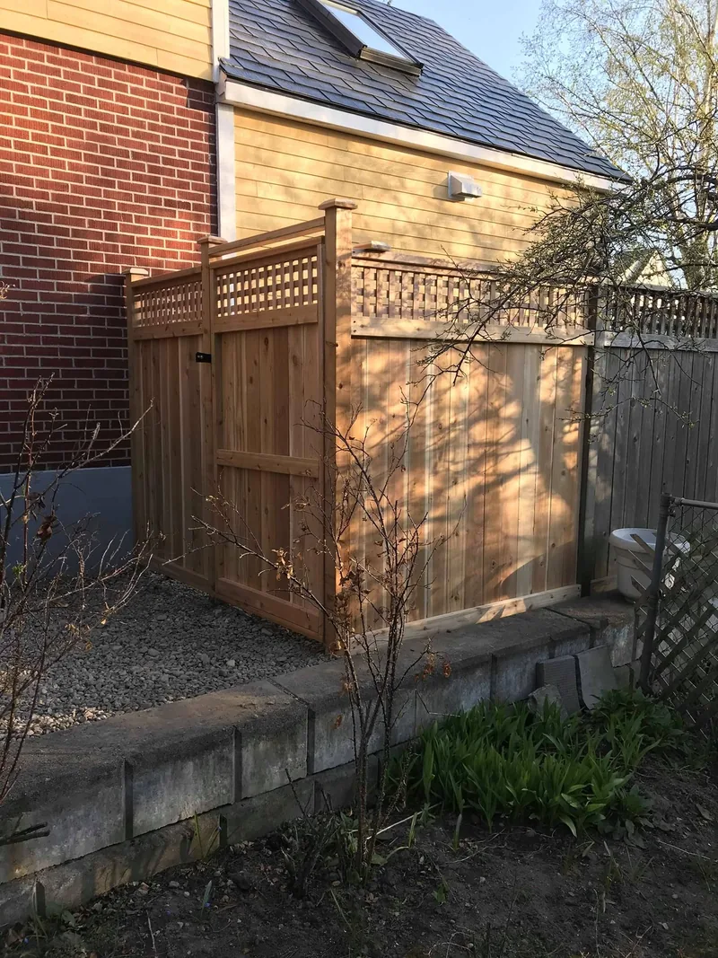 Wood fence with lattice top, set above a stone retaining wall
