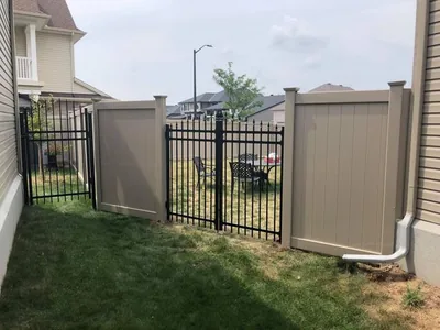 Beige PVC fence with a black aluminum gate