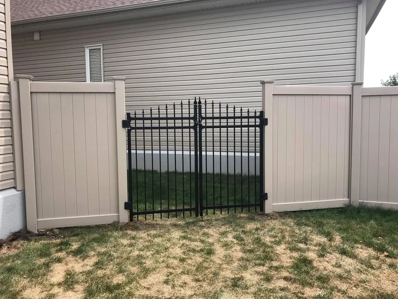 Beige PVC fence with a black aluminum section and gate