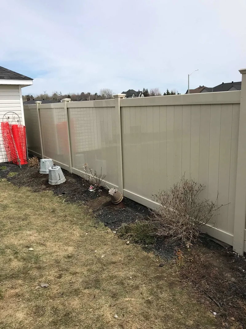 Full height beige PVC fence during installation