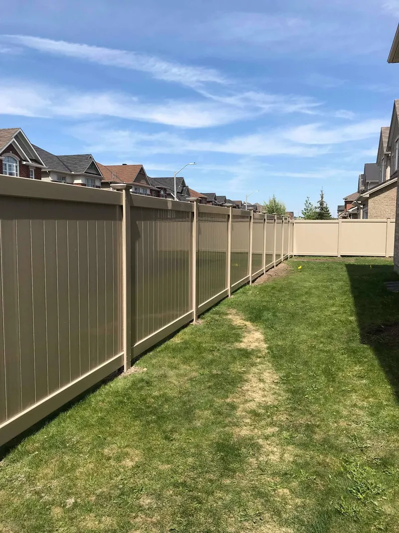 Long beige PVC fence seen from the street