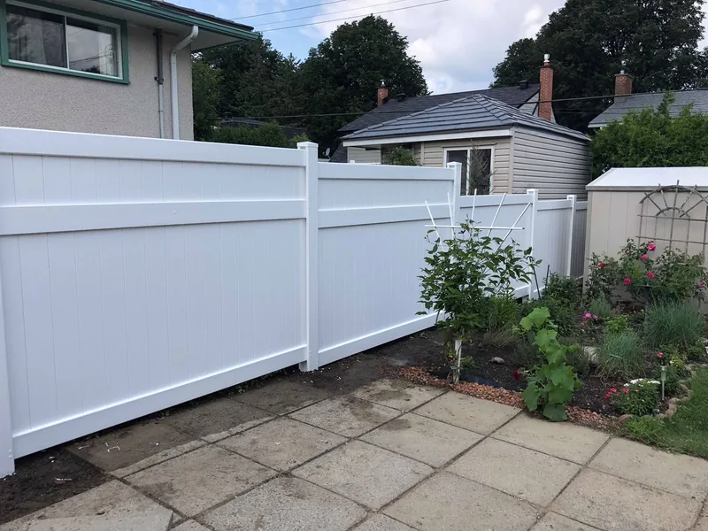 White PVC double gate opening onto a paving stone walkway