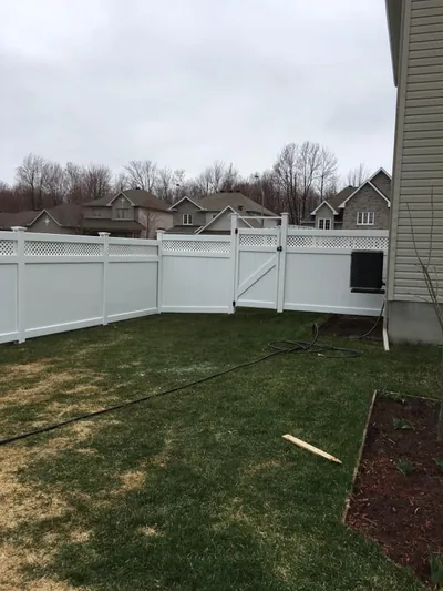White PVC fence enclosing a back yard