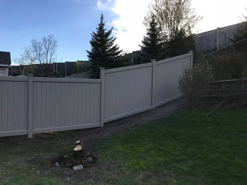 Long run of white PVC fence along a rear property line