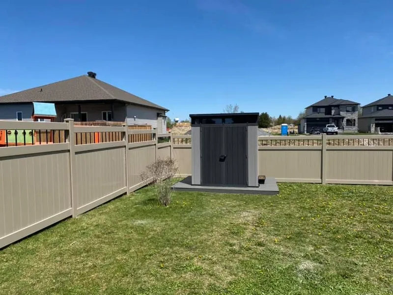 PVC fence enclosing a back yard with a shed and deck