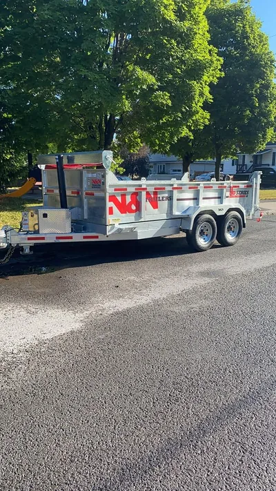 Clôtures DKA trailer and equipment parked on a residential street