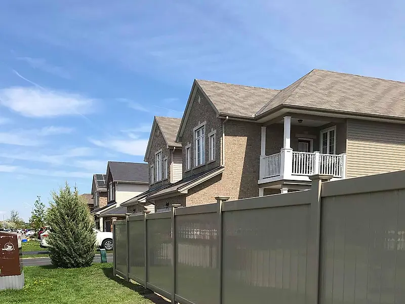 Grey PVC fence installed along a side yard